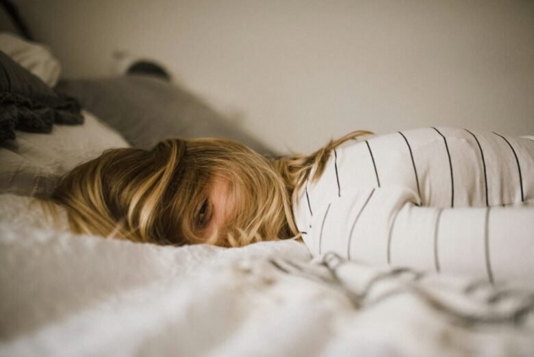 woman struggling with burnout and lying on bed